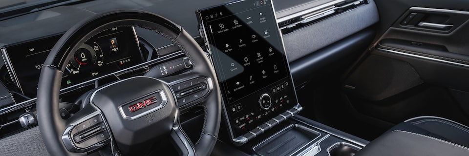 Close-up View of the Steering Wheel and Expansive Center Touchscreen in the Sierra EV