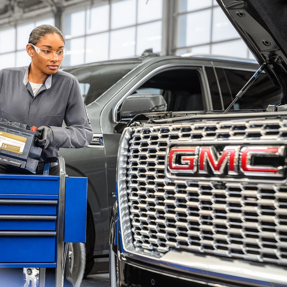 A GMC Mechanic Working Under the Hood of a GMC SUV