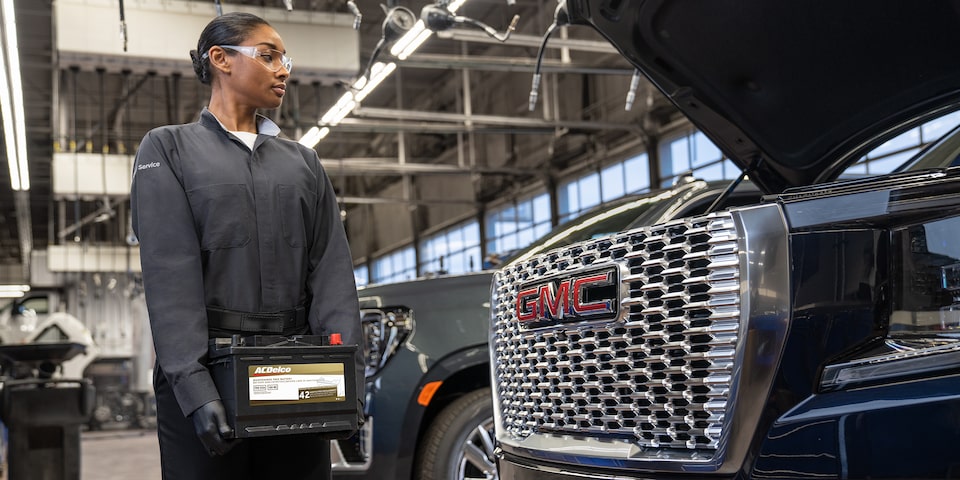 GMC Certified Service Technician Inspecting a Wheel on a Vehicle