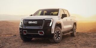 Front Three-Quarters View of the GMC Sierra AT4 EV Parked in the Desert at Sunset
