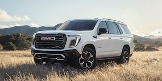 Front Three-Quarters View of the GMC Yukon AT4 Full-Size Off-Road SUV Parked on a Scenic Field