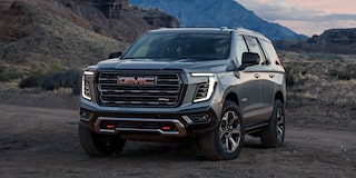Front Three-Quarters View of the GMC Yukon AT4X Full-Size Off-Road SUV Parked on a Scenic Field