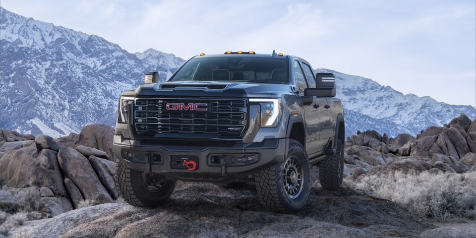 Front Three-Quarters View of a 2024 GMC Sierra HD AT4X AEV Off-Road Work Truck Parked on a Mountain Top