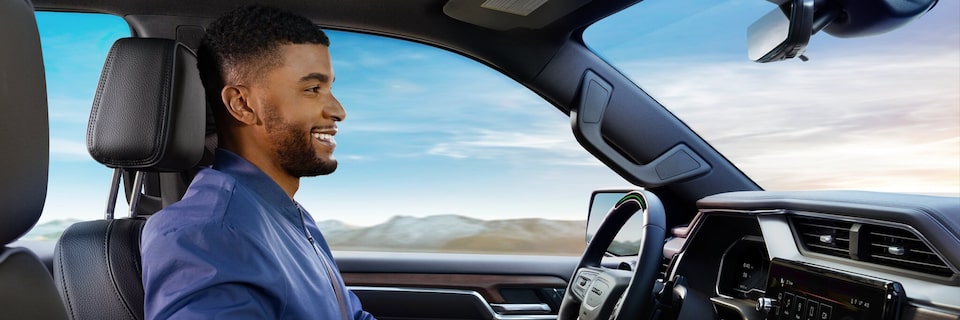 A Smiling Man Sitting in the Driver's Seat