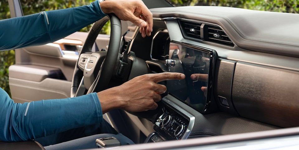 A Man Using the Infotainment System in a GMC Vehicle