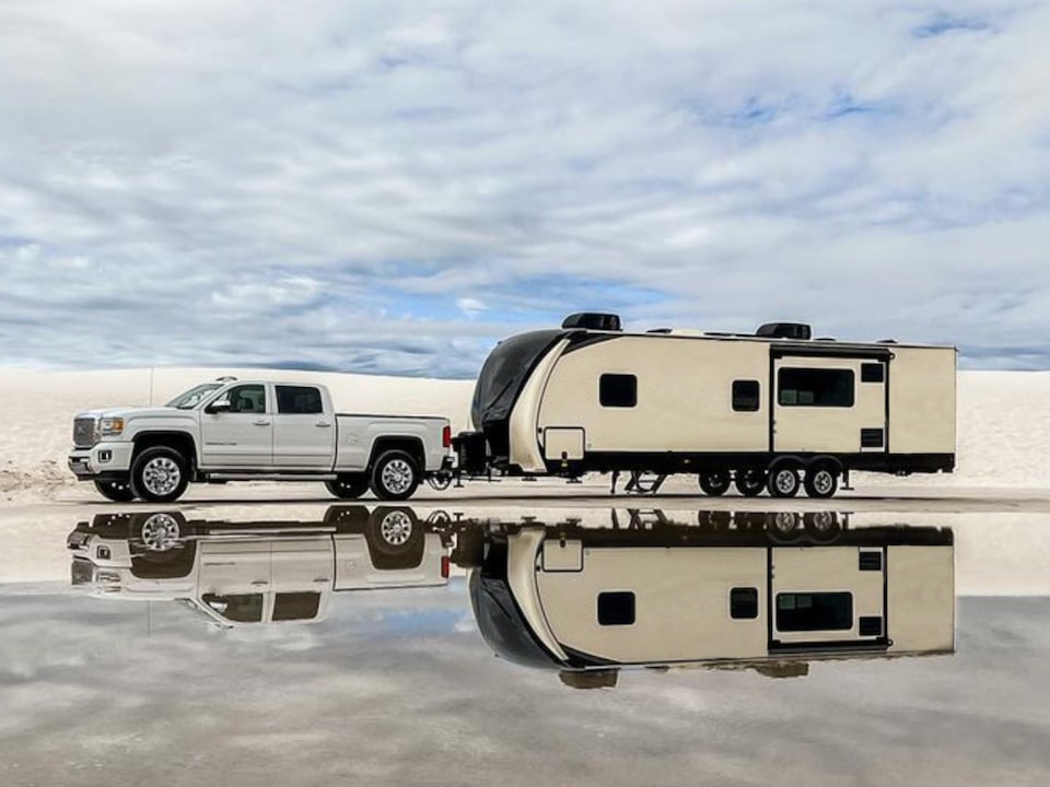 A GMC Truck Hauling a Large Trailer Parked at the Beach