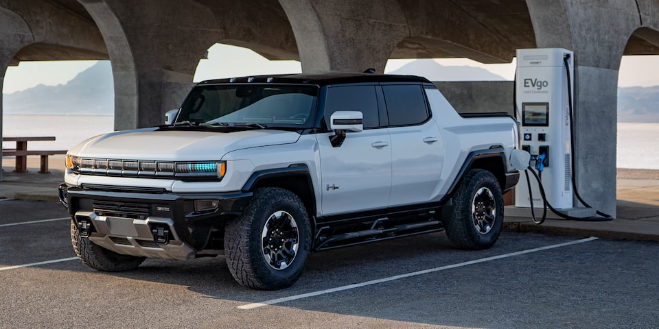 Front Three-Quarter View of a GMC HUMMER EV Pickup Truck Changing at a Public Charging Station