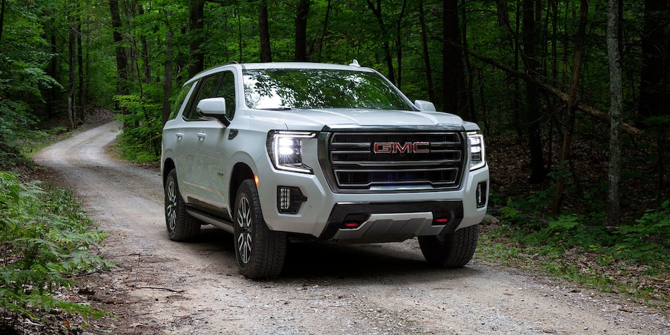 2024 GMC Yukon AT4 Driving Down a Forest Road