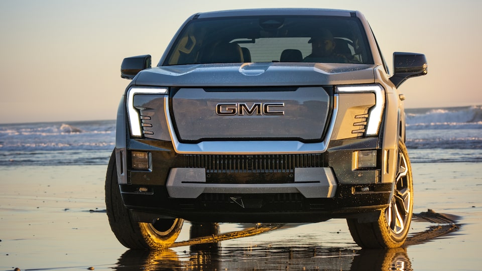 Close-up Front View of the GMC Sierra EV Truck on a Beautiful Beach at Sunrise