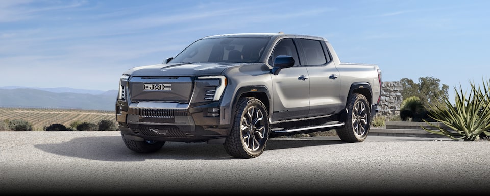 Wide Three-Quarter View of the GMC Sierra EV Truck Parked With Mountains in the Background