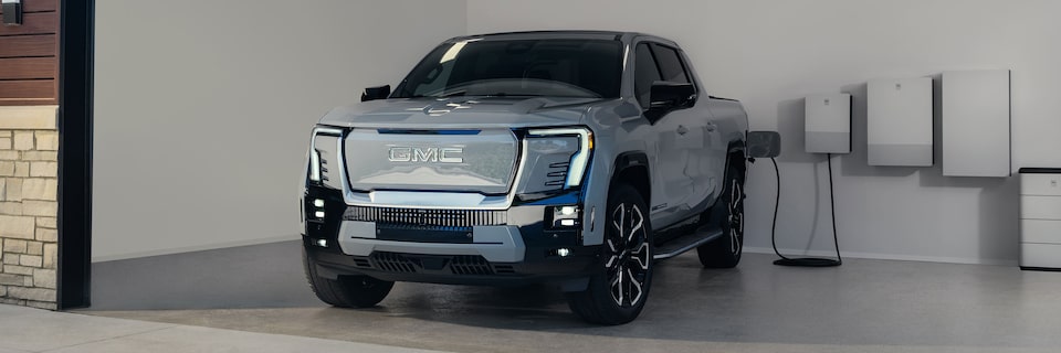 The 2025 GMC Sierra EV Pickup Truck Parked and Charging in a Home Garage